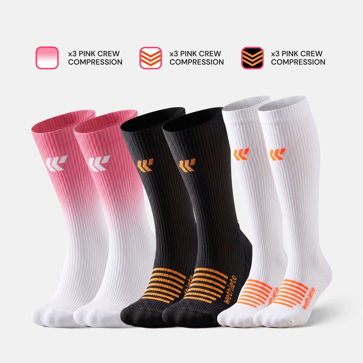 Bundle of compression socks: pink FlowLine crew, black and white mid calf and knee high socks, studio shot